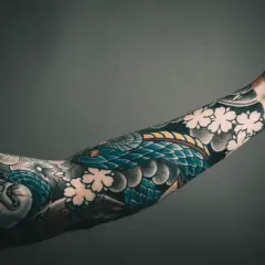 Rękaw z tatuażem yakuza: wąż oplatający twarz i kwiaty wiśni.
