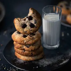 Ein Stapel weicher Chocolate Chip Cookies, perfekt für ein Cookies Rezept. Daneben ein Glas Milch.