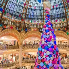 Arbre de Noël féerique fait de bonbons et étoiles, décorations colorées suspendues sous la coupole d'un grand magasin parisien.