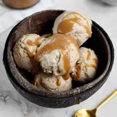 Schüssel mit erdnussbutter eis, beträufelt mit Karamellsauce. Ein goldener Löffel liegt daneben.