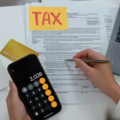 Calculating 401k tax rate implications with a calculator and tax forms.