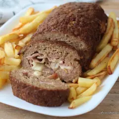 Polpettone ripieno di prosciutto e formaggio, cotto in friggitrice ad aria, servito con patatine fritte croccanti.