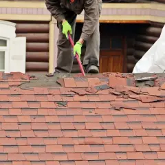 Dachdecker repariert ein Loch im Dach, entfernt alte Schindeln.