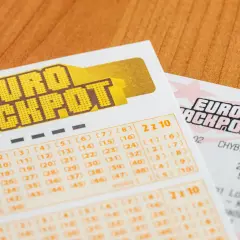 Kupony gry liczbowej Eurojackpot na drewnianym tle.