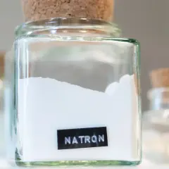 Glasbehälter mit Natron, bereit zum Putzen. Ein weiteres Glas mit Natron steht im Hintergrund.