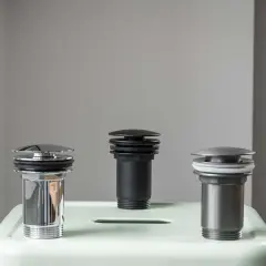 Trzy korki klik klak w różnych kolorach i wykończeniach. Dowiedz się, jak naprawić korek klik klak.