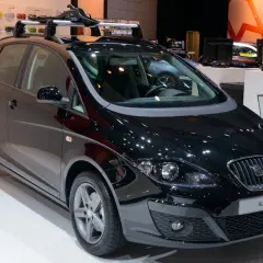 Czarny Seat Altea XL z relingami dachowymi, prezentowany na wystawie motoryzacyjnej.