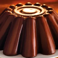 Budino al cioccolato lucido e invitante, con un disegno a spirale al centro e una forma a petali che promette un sapore intenso.