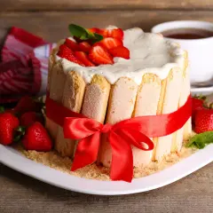 Charlotte aux fraises inratable, décorée de fruits rouges frais et d'une touche de menthe. Un délice visuel et gustatif.