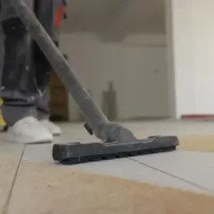 Nettoyage de carrelage après chantier : un aspirateur passe sur le sol pour enlever les débris.