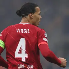 Piłkarz Virgil van Dijk w czerwonej koszulce Liverpoolu z numerem 4 i opaską "No to racism".