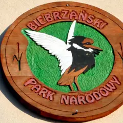 Drewniany symbol Biebrzańskiego Parku Narodowego z ptakiem i napisem.