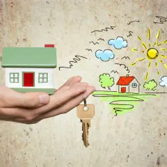 Hand hält Hausmodell & Schlüssel. Traumhaus-Zeichnung mit Sonne & Wolken. Gute Aussichten für die immobilienkauffrau ausbildung gehalt.