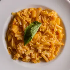 Piatto di pasta patate e provola cremoso, con un tocco di basilico fresco.