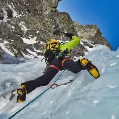Intensywna wspinaczka lodowa. Alpinista wspinający się po lodospadzie, używając czekana i raków.