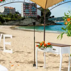 Decoración de boda en la playa de lagos Bueu: letras "LOVE", mesa de altar, flores y el mar azul.