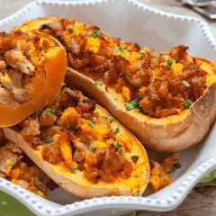 Courges butternut farcies à la saucisse, cuites à l'air fryer, garnies de persil frais, servies dans un plat blanc.