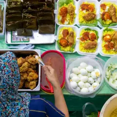Stoisko z pysznym, halal jedzeniem: ryż z kurczakiem, jajka na twardo, ogórki i sos.