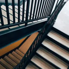 Escaleras modernas con barandillas oscuras y peldaños claros. Un lugar que invita a soñar con subir escaleras, alcanzando nuevas alturas.