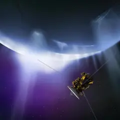 Sonda Cassini przelatuje obok lodowych gejzerów Enceladusa, księżyca Saturna, w kosmicznej purpurze.