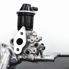 Metalowy element układu recyrkulacji spalin (EGR). Widoczny zawór z czarną obudową i metalową podstawą, połączony z rurą.