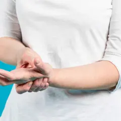 Mano che si tiene il polso, suggerendo tendinite polso ghiaccio o caldo per alleviare il dolore.