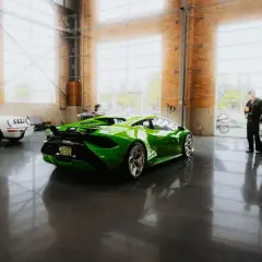 Une Lamborghini verte et une Porsche blanche dans un showroom. Le rachat LOA par concessionnaire est une option pour acquérir ces merveilles.