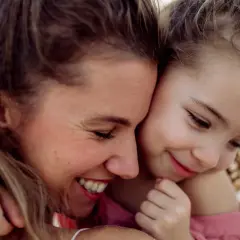 Een moeder en dochter knuffelen. De dochter vraagt zich af: "hoe oud ben je in groep 3?