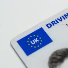 Fragment brytyjskiego prawa jazdy z flagą UK. To dokument potrzebny do jazda w podwójnej obsadzie zmiana kart.