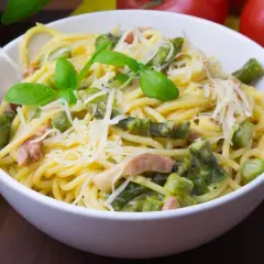Pyszna carbonara ze szparagami, udekorowana bazylią i parmezanem. Idealna na wiosenny obiad.