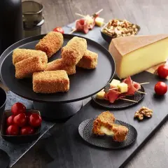 Croquettes dorées, garnies d'un fromage fondant, parfaites pour une raclette gourmande. Tomates cerises et noix accompagnent ce délice.