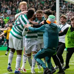 Piłkarze z Glasgow świętują zwycięstwo, otoczeni przez kibiców i młodych pomocników.