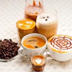 Różnorodne kawy, w tym latte z wzorem, espresso i napoje mrożone, idealne na keto dietę. Obok ziarna kawy.