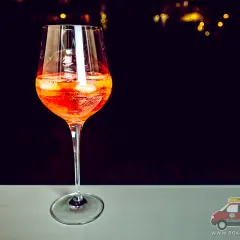 Orzeźwiający aperol z szampanem w kieliszku, z lodem i plasterkami pomarańczy. Idealny na letnie wieczory.