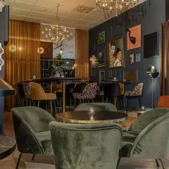 Mysig lounge med öppen spis och konst på väggarna. Välkommen till värdshuset Stopet för en avkopplande stund.
