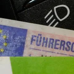 Führerschein mit EU-Sternen und "D" für Deutschland, daneben ein Lichtschalter. Bereit für die Fahrt nach § 24 StVG.