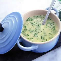 Krämig soppa med dill och gräslök, serverad i en ljusblå gryta. En sked vilar i den lena beurre blanc-såsen.