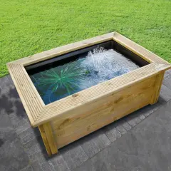 Un bassin préformé hors sol en bois avec une fontaine et une plante aquatique, prêt à être installé dans un jardin.