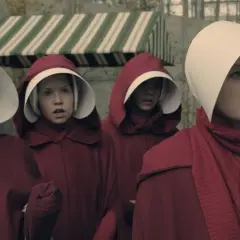 Quatre servantes écarlates, visages inquiets, se tiennent ensemble. L'une fait un clin d'œil. La servante écarlate saison 7 promet des tensions.