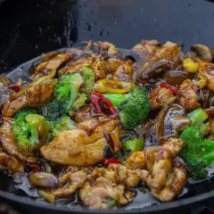 Kurczak hong kong w sosie z brokułami i papryką, smażony w woku.