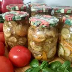 Słoiki z ogórkami gyros, obok pomidorów i papryki.