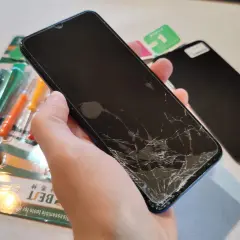 Gotowe narzędzia i nowy ekran czekają na wymianę pękniętego wyświetlacza w telefonie.