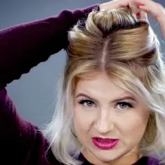 Mujer con pelo rubio corto haciendo un semirecogido con las manos.
