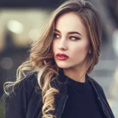 Blondynka z burzą falowanych włosów i wyrazistymi, czerwonymi ustami. Idealny kolor pomadki dla blondynek, który podkreśla urodę.