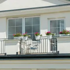 Eleganckie okno fasadowe z balkonem ozdobionym kwiatami.