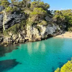 Aguas turquesas bañan las calas en Vera, rodeadas de acantilados rocosos y pinos frondosos. Un paraíso mediterráneo.
