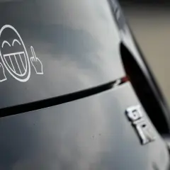 Lachendes Smiley-Gesicht mit Mittelfingern als Aufkleber am Auto. Welche Aufkleber am Auto sind erlaubt?