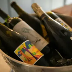 Butelki z winem w wiaderku z lodem. Zastanawiasz się, czy można przewozić alkohol w bagażu rejestrowanym? Sprawdź przepisy!