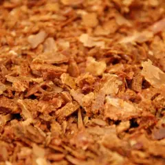 Zbliżenie na drobno pokruszony, brązowy propolis.
