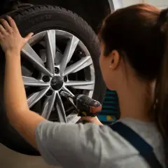 Mechanik używa klucza udarowego do kół, by dokręcić śruby w feldze.
